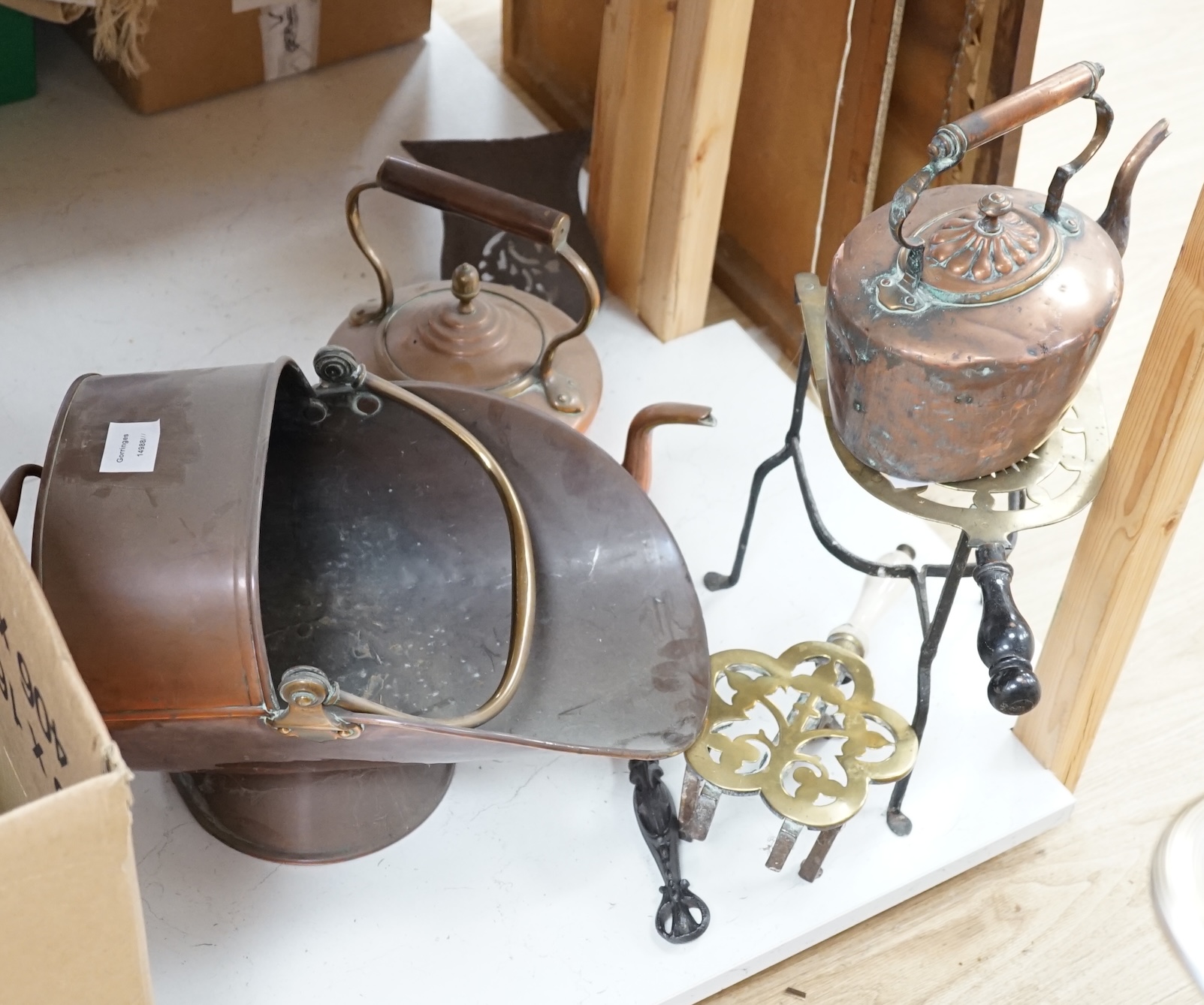 A Victorian copper helmet scuttle, two copper kettles, two trivets and a box of mixed copper and brass wares etc., scuttle 40cm deep. Condition - fair to good